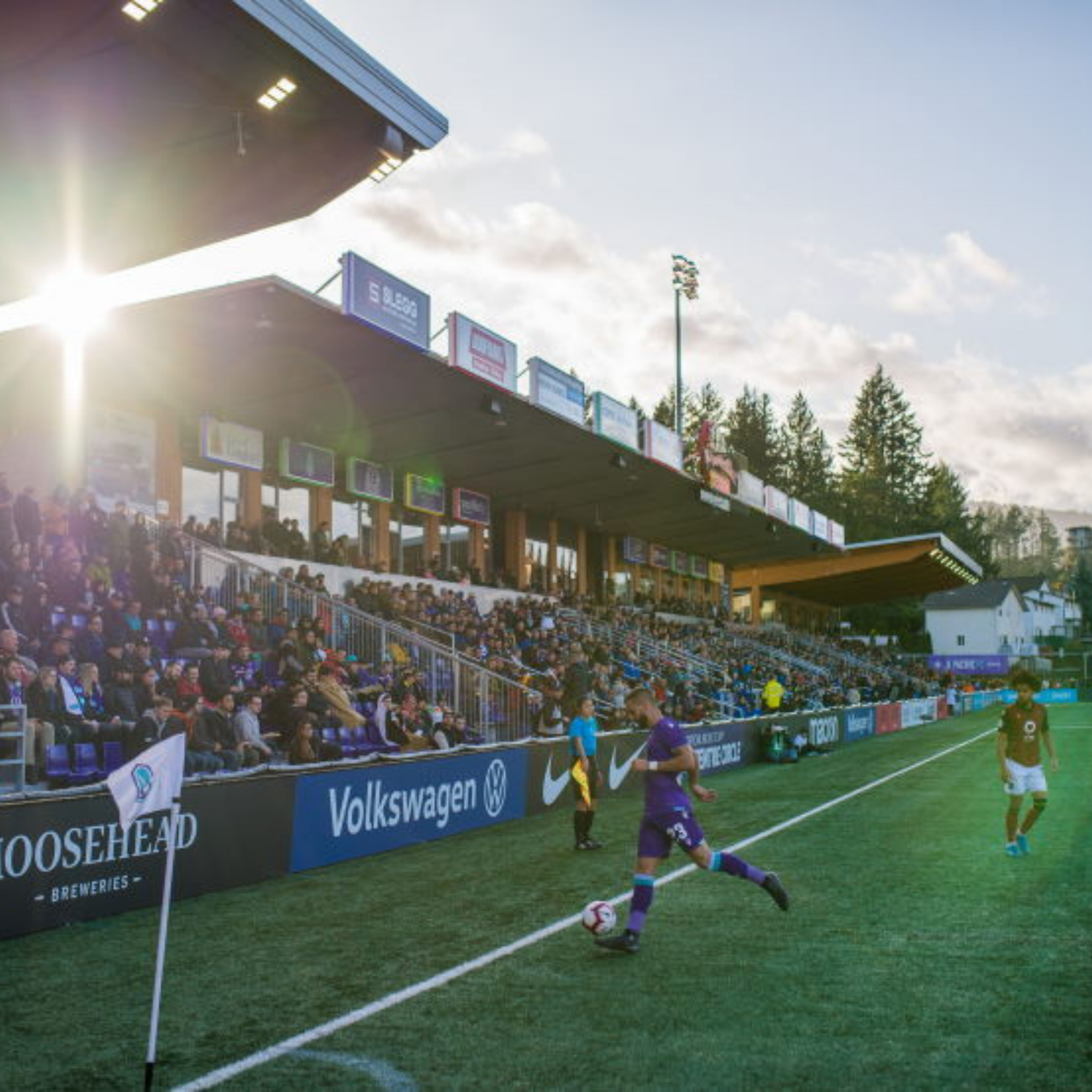 A professional soccer match in front of a packed grandstand in Langford